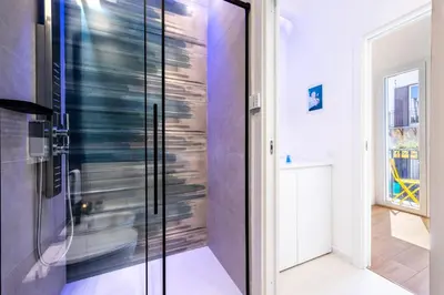 a glass shower door in a room with a window at Appartamenti Pellegrino Centro in Palermo