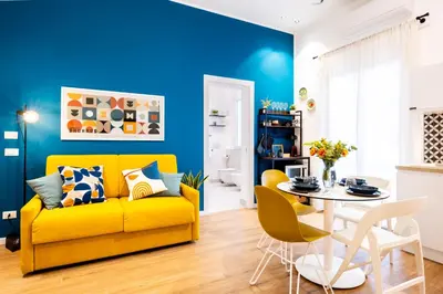 a living room with a yellow couch and a table at Appartamenti Pellegrino Centro in Palermo