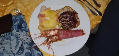a plate of food with meat and vegetables on a table at Sweet Home Pioppo in Pioppo