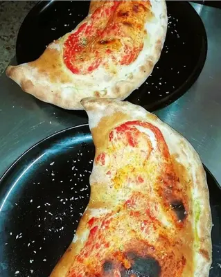 two slices of pizza sitting on black plates at Sweet Home Pioppo in Pioppo