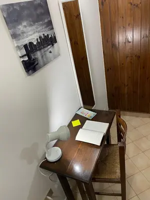 a wooden desk with a laptop and a lamp on it at Norman City House in Palermo