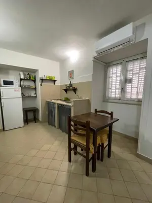 a kitchen with a wooden table and a kitchen with a refrigerator at Norman City House in Palermo