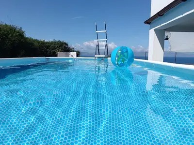 a swimming pool with a blue ball in the water at Villa dei tramonti in Terrasini