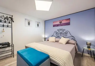 a bedroom with a large bed with a blue stool at Villa dei tramonti in Terrasini
