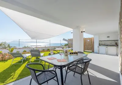 a dining room with a table and chairs on a patio at Villa dei tramonti in Terrasini