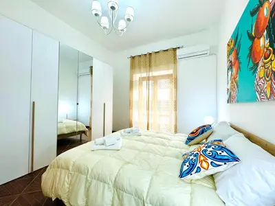 a bedroom with a large bed and a mirror at Il Moro Suite in Palermo