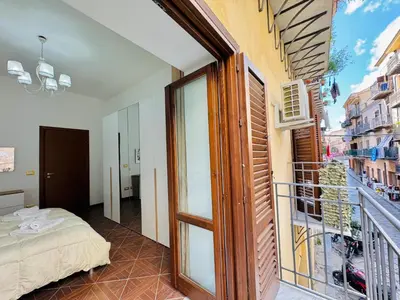 a room with a bed and a balcony with a view at Il Moro Suite in Palermo