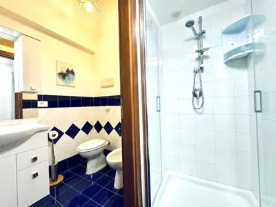 a bathroom with a shower and a toilet and a sink at Il Moro Suite in Palermo