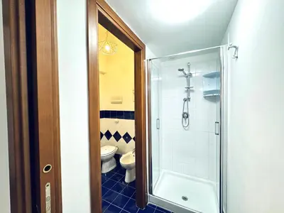 a bathroom with a toilet and a glass shower at Il Moro Suite in Palermo