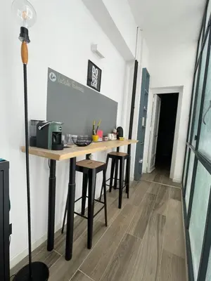 a communal table in a room with stools at UNA Room in Palermo