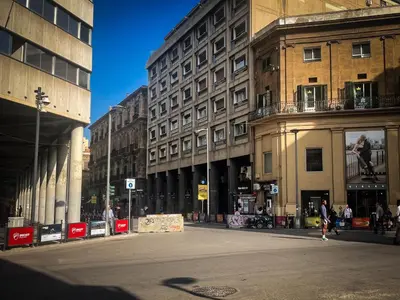 a city street with buildings and people walking on the street at UNA Room in Palermo