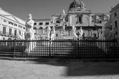 a black and white photo of a fence in front of a building at UNA Room in Palermo