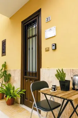 a table and a chair in front of a door at Casa Palù Sicilia in Altavilla Milicia