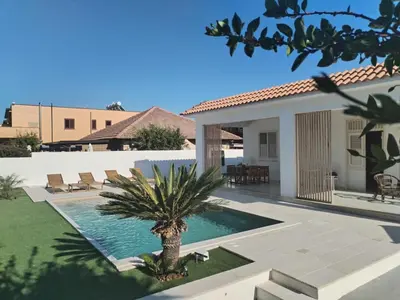 a swimming pool in a villa with a palm tree at Villa Marina di Calatubo in Alcamo