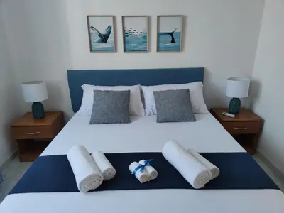a bedroom with a white bed with towels on it at Villa Marina di Calatubo in Alcamo