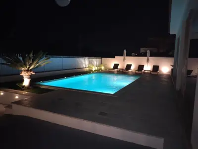 a swimming pool at night with chairs around it at Villa Marina di Calatubo in Alcamo