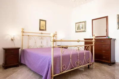 a bedroom with a bed with a mirror and a dresser at Casa Lucido di fronte la Tonnara in San Vito lo Capo