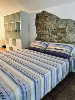 a bedroom with a large bed with a stone wall at B&B Al Porto Home in Palermo