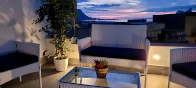 a balcony with two chairs and a table on a roof at Idea di Mare in Capaci