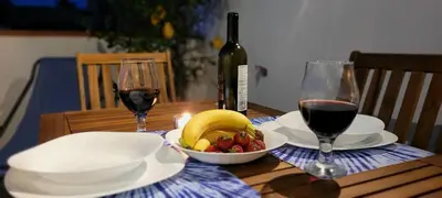 a table with two glasses of wine and a bowl of fruit at Idea di Mare in Capaci