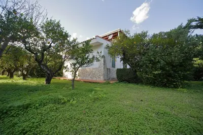 a white house with trees in a yard at Villa Globo Mondello in Palermo