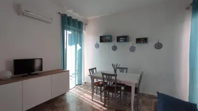 a dining room with a table and chairs and a television at Villa Globo Mondello in Palermo