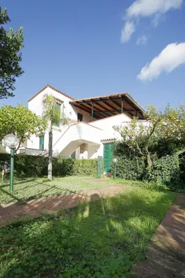 a white house with a garden in front of it at Villa Globo Mondello in Palermo