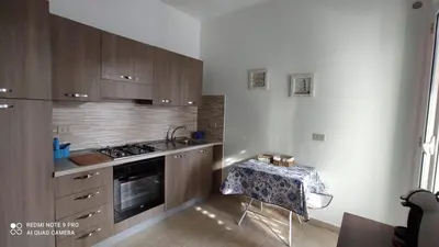 a kitchen with a table and a stove top oven at Villa Globo Mondello in Palermo