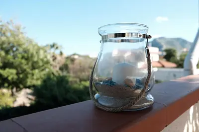 a glass jar filled with sand and rocks on a ledge at Villa Globo Mondello in Palermo