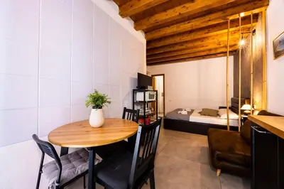 a small room with a table and a bedroom at Lampionelli 12 Apartment in Palermo