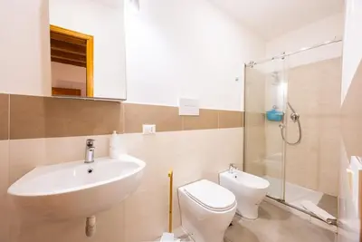a bathroom with a sink and a toilet and a shower at Lampionelli 12 Apartment in Palermo