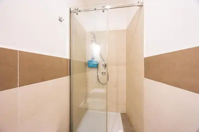 a shower with a glass door in a bathroom at Lampionelli 12 Apartment in Palermo