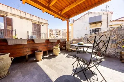 a patio with chairs and a table on a building at Lampionelli 12 Apartment in Palermo