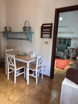 a kitchen with a table and chairs and a living room at Bellammari Holiday House in Palermo