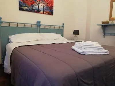 a bedroom with a bed with towels on it at Bellammari Holiday House in Palermo