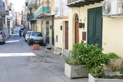 a street with cars parked on the side of a building at Duomo Suite - A Step from the Cathedral in Monreale