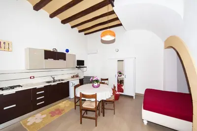 a kitchen and dining room with a table and a couch at Visitsicilia Donn'Anna in Castellammare del Golfo