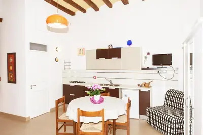 a kitchen with a table with a vase of flowers on it at Visitsicilia Donn'Anna in Castellammare del Golfo