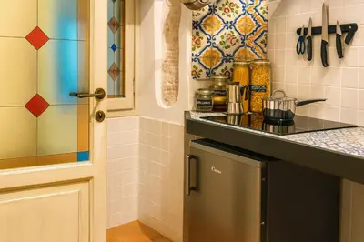 a small kitchen with a counter and a refrigerator at AthaHome Deluxe in Palermo
