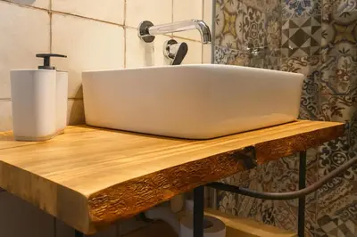 a bathroom sink on a wooden counter with a soap dispenser at AthaHome Deluxe in Palermo