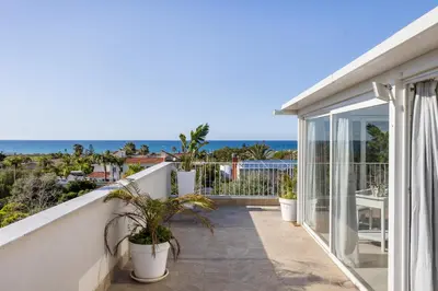 a balcony with potted plants and a view of the ocean at Villa Angela By DomuSicily in Capaci