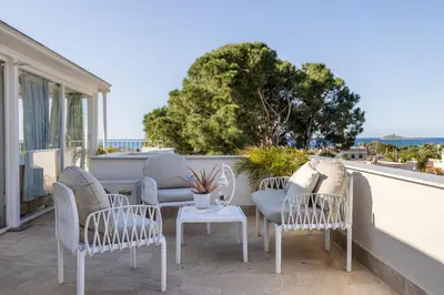 a group of chairs and a table on a balcony at Villa Angela By DomuSicily in Capaci