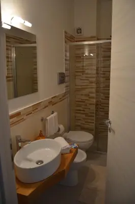 a bathroom with a sink and a toilet and a mirror at B&B Albatros in Castelluzzo