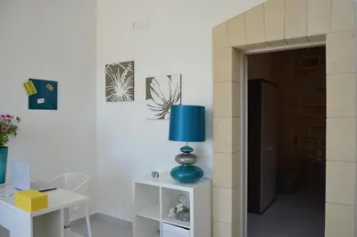 a living room with a blue lamp on a table at B&B Albatros in Castelluzzo