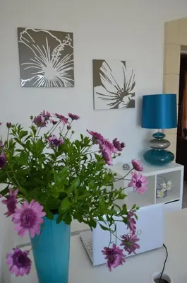 a desk with a blue vase with purple flowers on it at B&B Albatros in Castelluzzo
