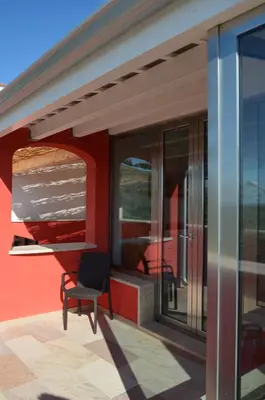 a chair sitting on a patio next to a building at B&B Albatros in Castelluzzo