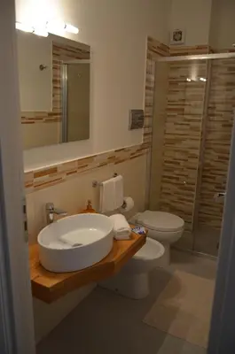 a bathroom with a sink and a toilet and a mirror at B&B Albatros in Castelluzzo