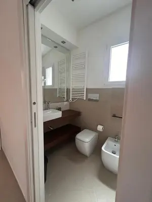 a bathroom with a toilet and a sink and a mirror at Zisa Apartment Palermo in Palermo