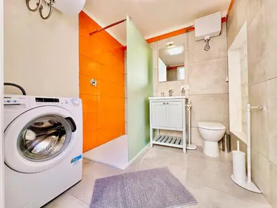 a bathroom with a washing machine and a toilet at Sea Life Giulia, spiaggia a 200 mt in Alcamo Marina