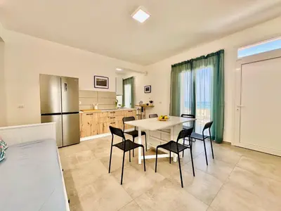 a kitchen and dining room with a table and chairs at Sea Life Giulia, spiaggia a 200 mt in Alcamo Marina